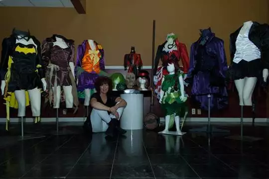 Lisa sitting near multiple different outfits that she created for a GenCon group cosplay.